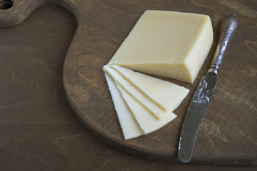 Cheese sliced on wooden Board