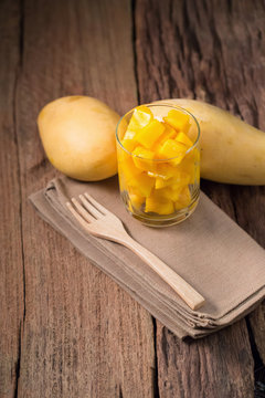Mango fruit and mango cubes In the glass on the wooden table