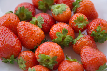 Red strawberries on a white plate                   