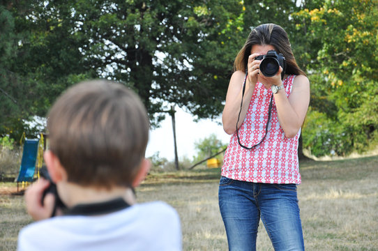 Mom  make photos of her little son. Woman photographer taking photo of little boy