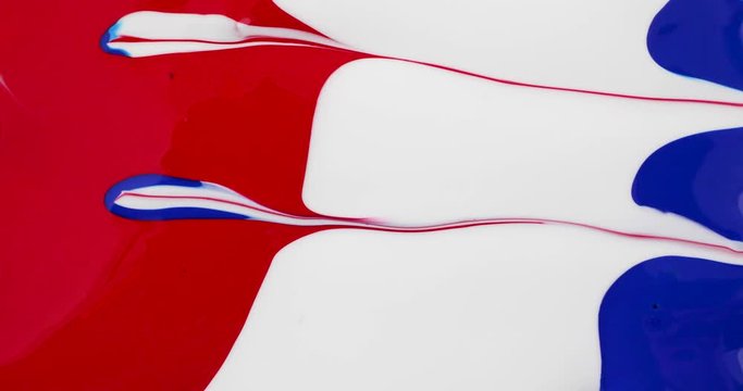 Using a small paintbrush to make an abstract painting with red white and blue poster paint.
