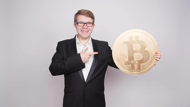Business man holding big bitcoin in his hands. Cryptocurrency, people, technology, money and future concept