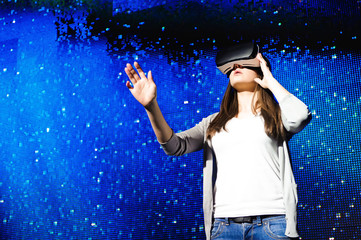 a beautiful girl wearing a virtual reality device, standing on the background of the sky