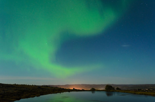 Autumn Aurora, the polar lights in the sky over the river,lake and hills at night .