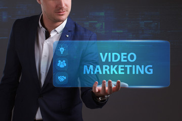 Business, Technology, Internet and network concept. Young businessman working on a virtual screen of the future and sees the inscription: Video marketing