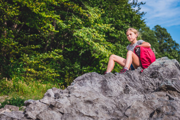 Naklejka na ściany i meble Girl resting on a rock