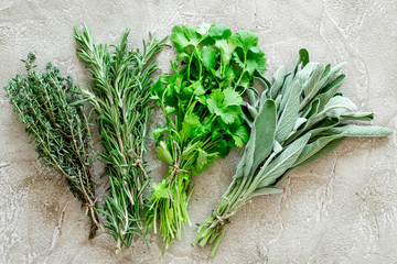 making spices with fresh herbs and greenery for cooking stone kitchen table background top view