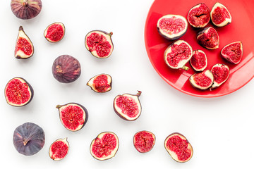 Plate of fresh blue figs on white background top view