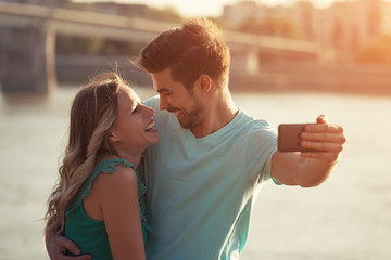 Young happy couple taking selfie outdoor.