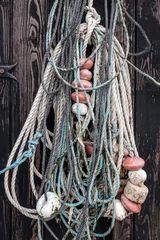 Foto op Canvas An old fishing net hanging on rustic wooden wall © Erik_AJV