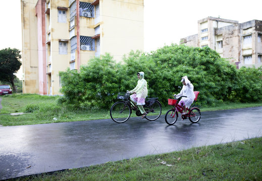 Teenagers wearing rain proof and cycling