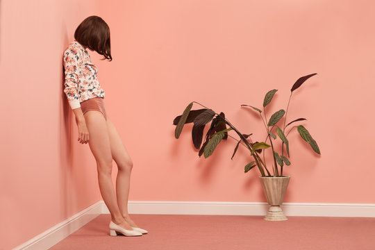 Woman leaning on wall in pink room