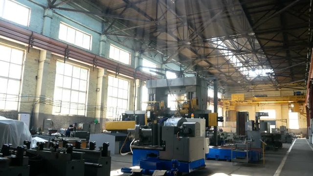large workshop with machine tools illuminated by rays