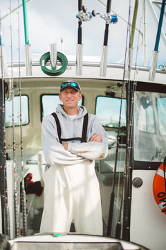 Proud boat captain standing in doorway of cabin.