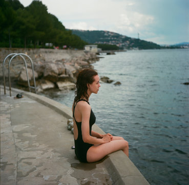 A profile portrait of a young beautiful woman in front of sea