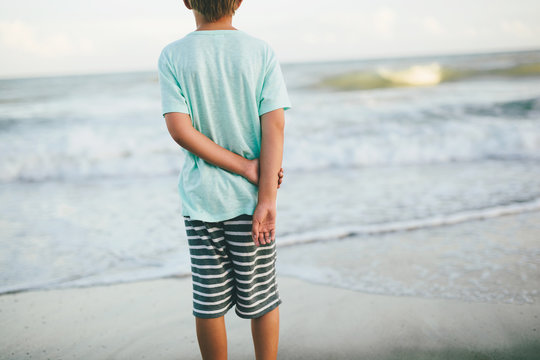 behind a boy looking out at the ocean