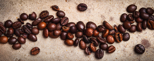 Whole Coffee beans on textured rusty background. Flat lay