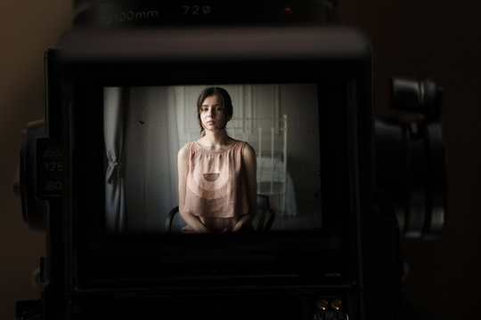 portrait of a beautiful girl through the vintage camera viewfinder