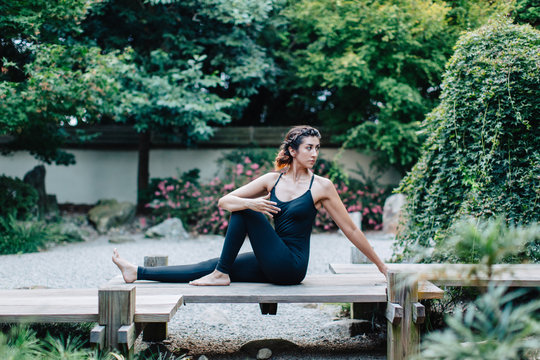 Healthy young woman doing a yoga pose outside