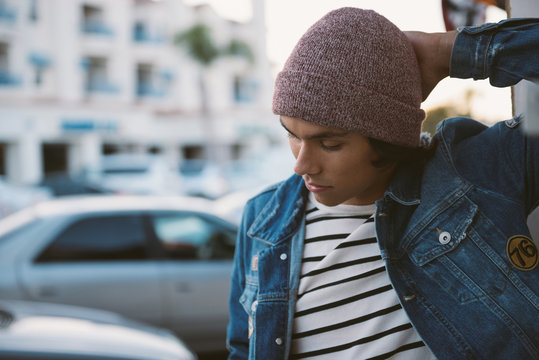 Young male teen hanging out outside with a beanie and denim jacket