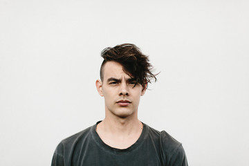 expressive portrait of man against white wall