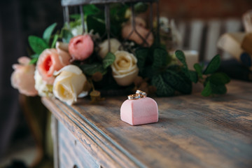 Wedding gold rings on a decorative pillow with flowers close-up. Jewelry concept
