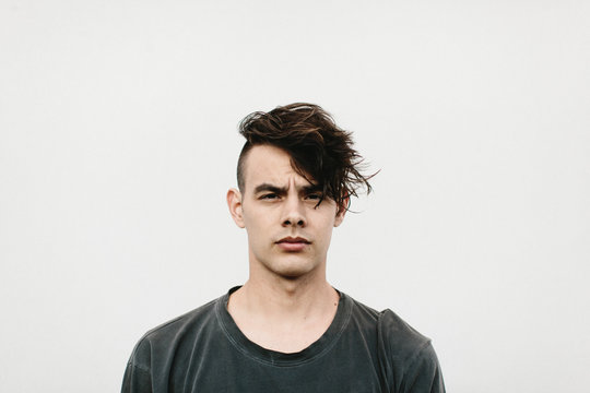 expressive portrait of man against white wall