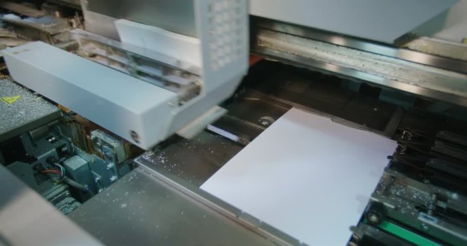 Book Binding Machine Close Up Move Above. a book moves in the machine getting prepared for the binding of the book spine
