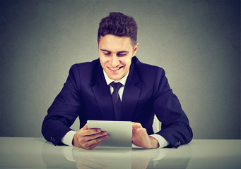 Smiling young businessman using a tablet computer