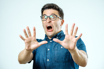 Man with scared expression on his face making frightened gesture with his palms