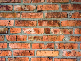 Fototapeta premium A close-up shot of a rough brick masonry wall lined with red clumsy brick for creativity, textures and background.
