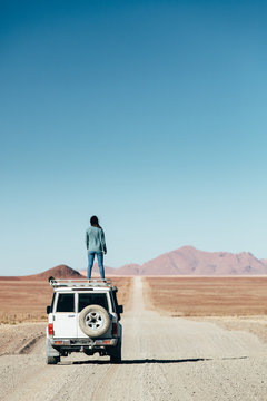Woman on a roadtrip in an expansive empty desert