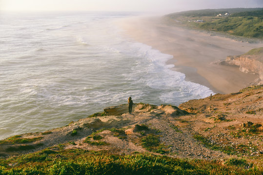 Woman watching the Atlantic Ocean from a cliff