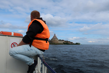 Fototapeta premium a man swims on a yacht to a fortress that is located on an island