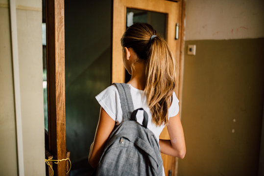 Girl with ponytail and backpack walking to the school