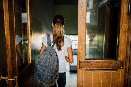 Young girl with ponytail and backpack going to school