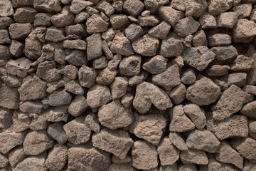Background -  wall composed of lumps of volcanic lava