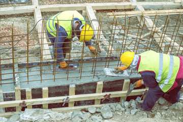 Builders crew leveling concrete footing pour 2