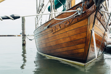 Bow of a wooden ship docked by a pier