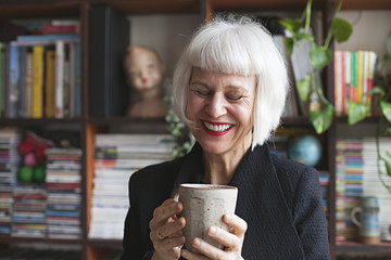 Stylish older woman indoors in front of books and records