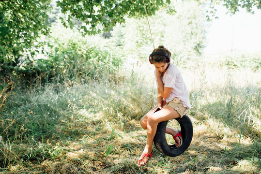 Teen Listening To Music On A Swing