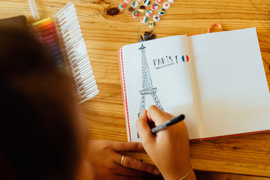 teen drawing Eiffel tower in journal
