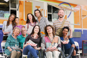 Smiling diverse friends stand by food truck