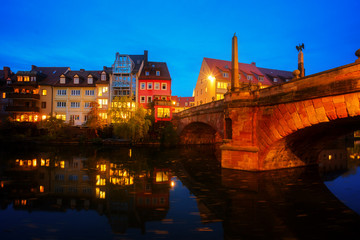 View of Karlsbrucke and Old town of Nuremberg over Pegnitz river at night, Germany, retro toned