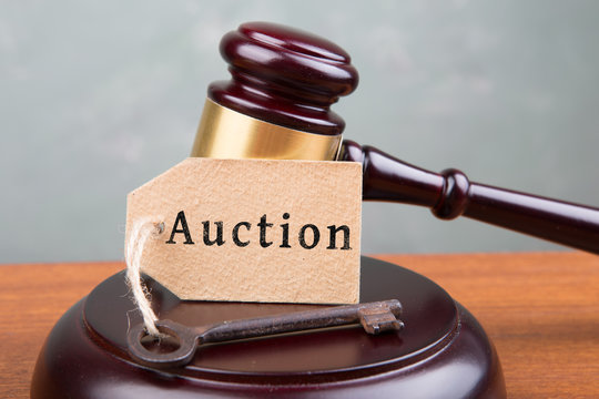Real estate sale auction concept - gavel and key on the wooden table
