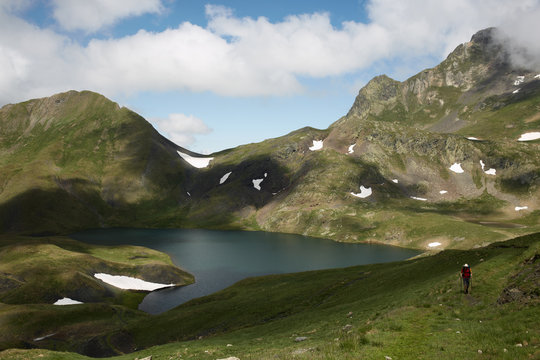 Lonely hiker in a mountain lake landscape