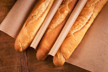 Fresh crispy French loaves on wrapping paper