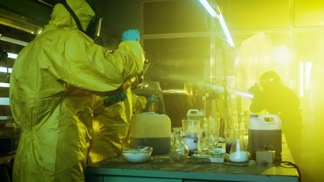 Fully Armed Special Anti-Narcotics Task Forces Soldier Arrests Two Clandestine Chemists Working in the Drug Producing Underground Laboratory. A lot of Drug Production Equipment is Lying around.