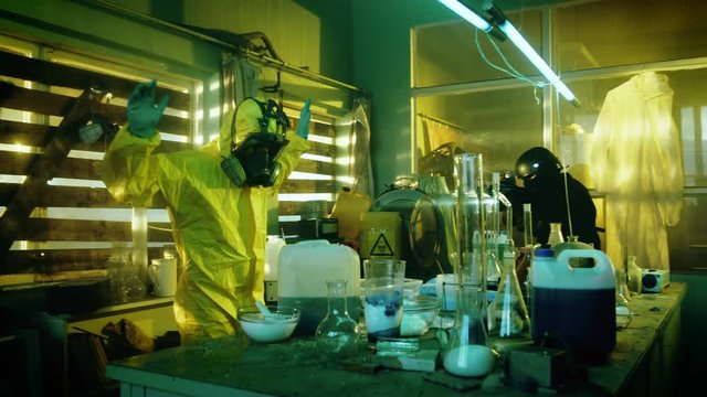 Fully Armed Special Anti-Narcotics Task Forces Soldier Arrests Two Clandestine Chemists Working in the Drug Producing Underground Laboratory. Chemists Raise Hands and Surrender.