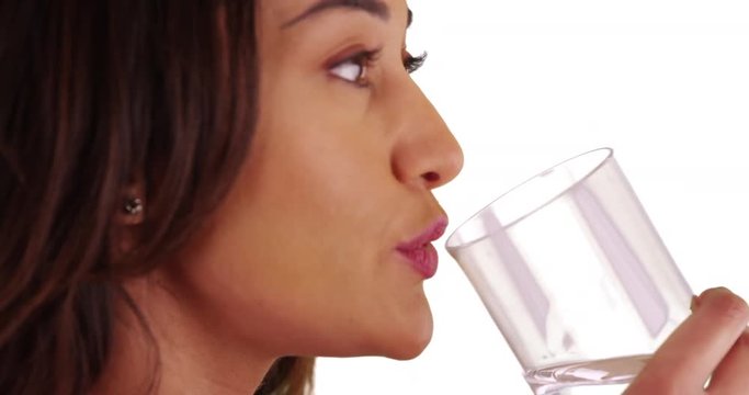 Close Up Of Healthy Latina Female Taking Pill Then Drinking Water On White Background. Portrait Of Young Woman Taking Daily Supplement In Studio. 4k 